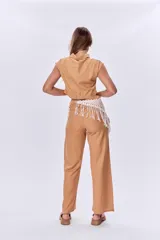 Camisa corta color ocre de lino, con cuello clásico, cierre frontal con botones y mangas cortas con solapas.