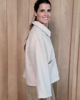 Chaqueta de textura bouclé en color bordó, con corte oversize, cuello camisero, cierre frontal y bolsillos laterales.