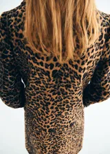 Abrigo largo de corte recto con estampado de leopardo, cuello camisero, cierre frontal con botones y bolsillos laterales. Cuenta con forro interior y manga larga.