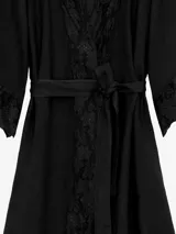 Kimono de lino color beige, de silueta fluida, con escote en V, mangas amplias, lazo para ajustar en la cintura y delicadas guardas de encaje en solapas y puños.