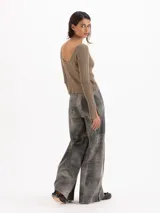 Pantalon de cuero ovino gris con diseño de pata ancha y recortes geométricos a la altura de las rodillas.