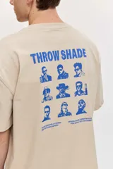 Remera de corte oversize color blanco tiza, de manga corta y cuello redondo, con pequeño estampado gráfico azul en el pecho.