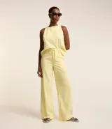 Pantalón wide leg color amarillo pálido, confeccionado en sarga leve, con cintura alta y cordón de ajuste.