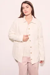 Sobrecamisa color crudo de algodón peinado, con cuello camisero, cierre frontal con botones de nácar, mangas largas con puños abotonados, bolsillos de parche en el pecho y corte recto.