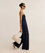 Pantalón recto de cintura baja, confeccionado en punto roma con rayas verticales en hilo teñido. Presenta trabillas en la cintura, cierre tradicional, pliegues, bolsillos cargo laterales y bolsillos falsos atrás.