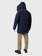 Parka azul marino de poliéster con capucha y ribete de piel, cierre con botones y logo de Canada Goose en el brazo.