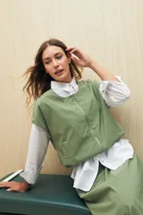 Chaleco color beige sin mangas de silueta relajada, con escote redondeado, cierre frontal con cremallera y ruedo elastizado.