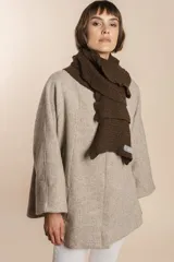 Bufanda tejida en punto fantasía con textura cuadriculada y bordes con efecto de volado. Confeccionada en lana fina sin teñir.
