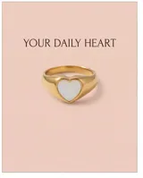 Anillo de acero dorado con diseño de corazón incrustado en nácar blanco.