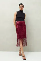 Falda larga negra de lentejuelas con terminación en flecos.