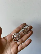 Par de caravanas plateadas con forma de espiral.