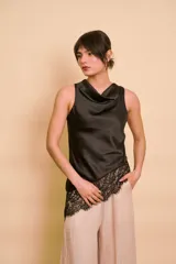 Blusa sin mangas de satén color tostado, con cuello redondo drapeado y detalle asimétrico de encaje en el ruedo.