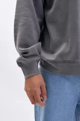 Buzo deportivo gris oscuro con efecto lavado, cuello redondo y corte holgado.