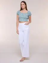 Top corto estampado con diseño floral en tonos azules y verdes sobre fondo blanco, con escote corazón fruncido con elástico, mangas cortas abullonadas y pretina ancha bajo el busto.