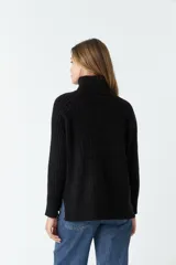 Sweater negro de punto con cuello alto y mangas largas.
