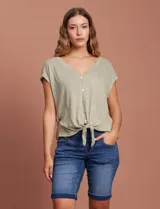 Blusa color beige de modal con escote en V, abertura central con botones y ruedo anudado. Marca French Laundry.