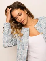 Chaqueta de tweed azul con cuello a la base, abertura central y bolsillos delanteros. Puños con aplique de botones perlados y forro interno.