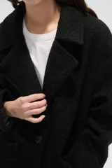 Tapado de lana con diseño a cuadros en tonos marrones y beige, de corte holgado, con cuello de solapa y cierre frontal con botones.