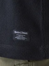 Campera de abrigo tipo fleece color burdeos con detalles en azul marino. Tiene cuello alto, cierre frontal y bolsillos laterales con cierre.