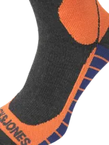 Medias deportivas extra largas diseñadas para ski, en color gris oscuro con detalles geométricos en naranja y franjas violetas en la planta del pie. Confeccionadas en tejido de punto elástico.
