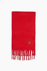 Bufanda de tejido suave color rojo, con diseño liso y flecos en los extremos. Incluye una pequeña etiqueta de cuero sintético con logo en una de las esquinas.