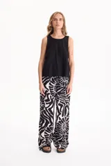 Pantalón ancho de lino con estampado en blanco y negro, cintura elástica con cordón de ajuste y bolsillos laterales.