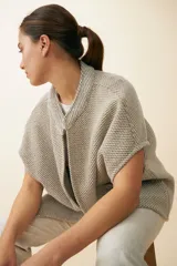 Chaleco marrón de lana con cuello mao, solapas pronunciadas, bolsillos ojal y terminaciones envivadas.