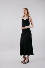 Vestido midi negro con breteles finos y escote drapeado.