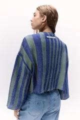 Sweater tejido de punto a rayas texturizado con lurex, color verde y azul. Cuenta con un calce oversize, mangas tres cuartos y cuello bote.