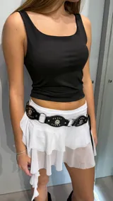 Minifalda blanca con volados de tul, diseño de tiro bajo y short incorporado.
