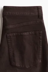 Jean de corte bootcut y tiro alto en color marrón oscuro, con diseño de cinco bolsillos y raya marcada en el frente y la espalda.