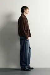 Jeans tapered wide fit de hombre, confeccionados en denim de algodón con efecto lavado en tono azul oscuro. Presentan diseño de cinco bolsillos, tiro medio, corte relajado y cierre frontal con cremallera y botón.