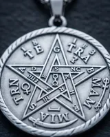 Collar de acero con dije circular grabado con el símbolo del Tetragramaton y cadena de eslabones finos.