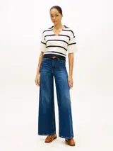 Chomba de punto Tommy Hilfiger de corte amplio, con diseño de rayas horizontales blancas y azul marino, manga corta, hombros caídos y cuello en V con solapa.