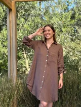 Vestido camisero color beige claro, de lino 100% natural, con botones de nácar, bolsillo delantero y mangas 3/4 con botón para recogerlas. Diseño asimétrico, más largo en la parte trasera.