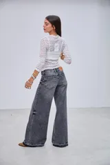 Remera blanca de encaje con diseño texturizado, cuello alto y mangas largas.