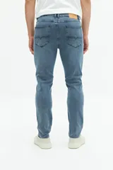 Pantalón de jean negro de corte recto y tiro medio, con bolsillos delanteros y traseros, y presillas para cinturón. Confeccionado en algodón y spandex.