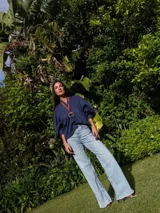Camisa de lino blanca, de corte oversize, con mangas largas abullonadas, cuello mao y botones. Es más larga en la parte trasera e incluye un tajo en la espalda.