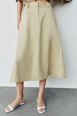 Falda midi de tiro alto color beige, con bolsillos delanteros, cintura con trabillas y cierre frontal con cremallera y ganchos metálicos.