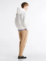 Buzo blanco de Tommy Hilfiger con capucha, cordones ajustables, logo bordado en el pecho, bolsillo tipo canguro, puños y bajo acanalados. Confeccionado en mezcla de algodón y poliéster.