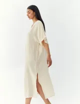 Vestido largo color crema, de corte amplio y mangas cortas.