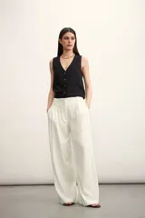 Pantalón de corte sastrero y tiro alto, con diseño de pierna ancha y pinzas frontales. Cuenta con bolsillos laterales y cierre frontal con botón oculto.