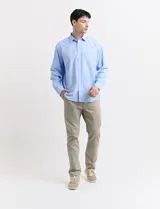 Pantalón de vestir marrón, de corte recto, con bolsillos laterales y traseros. Se ajusta a la cintura con cinturón de cuero marrón.