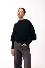 Chaqueta tejida de silueta recta con botones frontales y mangas tres cuartos terminadas en puños de piel sintética suave. Diseño versátil que permite usarla con los botones hacia adelante o hacia atrás.