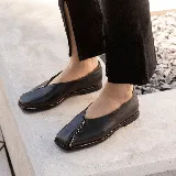 Zapato bajo de cuero negro con punta cuadrada y detalle de cierre en la capellada.