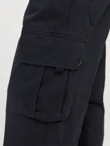 Pantalón cargo de corte amplio y tiro medio, confeccionado en sarga de algodón resistente. Presenta bolsillos laterales tipo cargo, bolsillos delanteros y traseros, cierre con cremallera y diseño de pierna ancha.