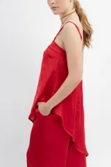 Musculosa roja de seda con escote recto, tirantes finos y corte irregular con tajo lateral.