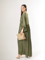 Vestido largo de satén italiano color verde militar, con escote en V profundo, corte oversized de caída amplia y fluida, y mangas tres cuartos con detalles de volados en los puños.