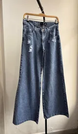 Pantalón de jean azul de tiro bajo, corte wide leg y detalles rotos.