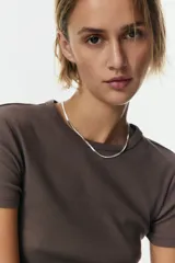 Remera marrón de manga corta y cuello redondo, confeccionada en tejido de punto acanalado con diseño entallado y bajo recto.